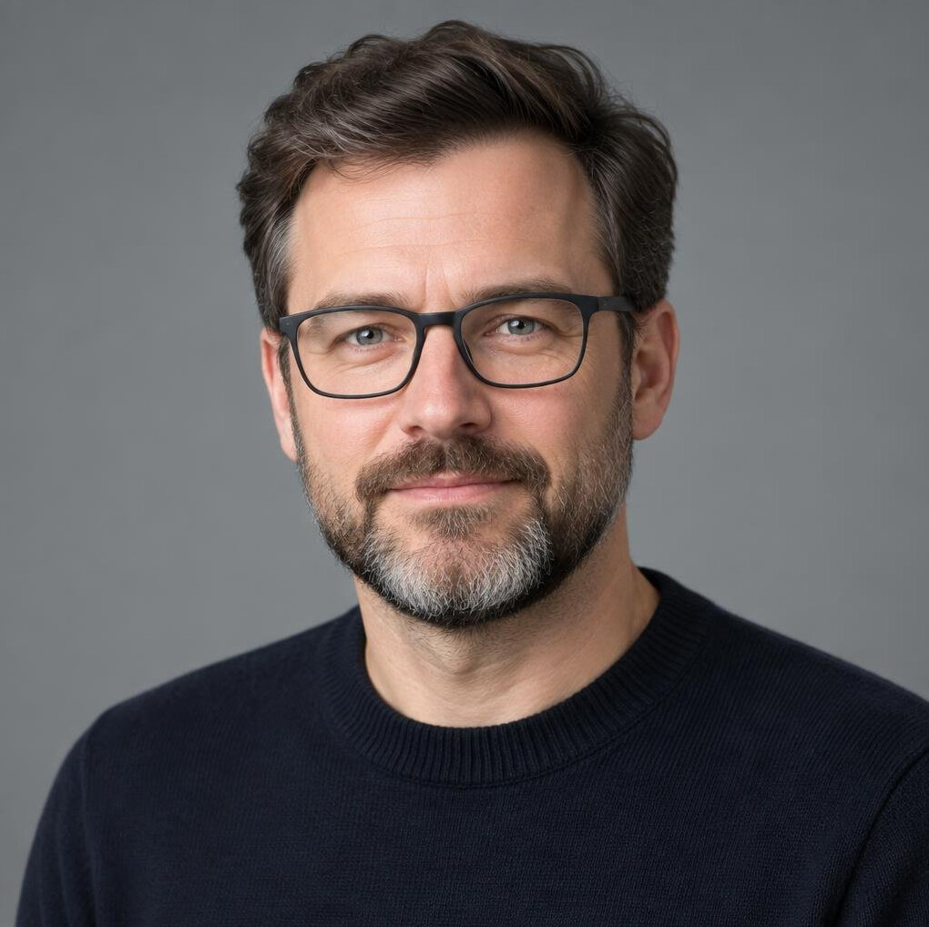 Studio portrait of a middle-aged man with glasses and a beard